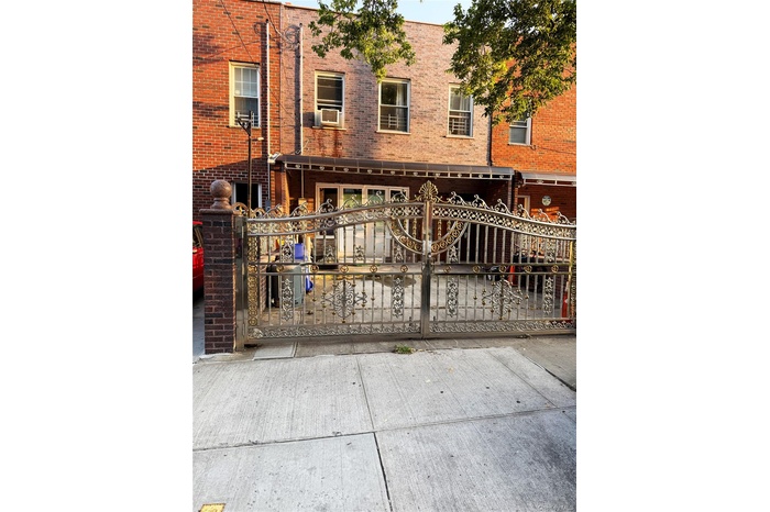 View of front of house with brick siding and a gate