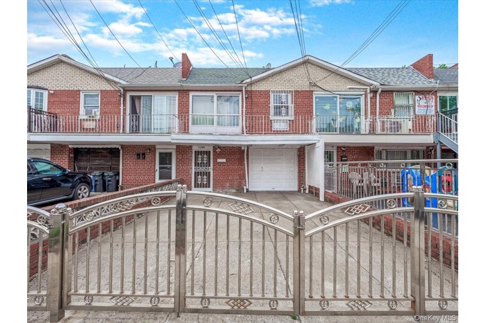 Townhome / multi-family property featuring brick siding, a fenced front yard, a garage, and a shingled roof