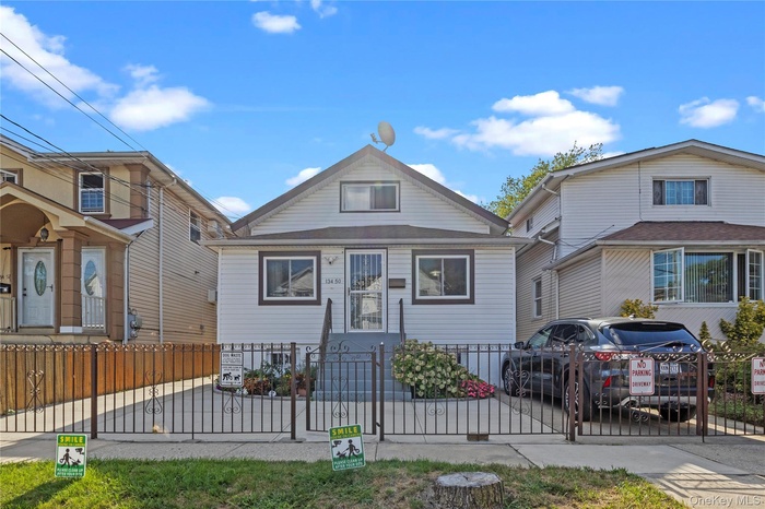 View of front of property featuring a fenced front yard and a gate