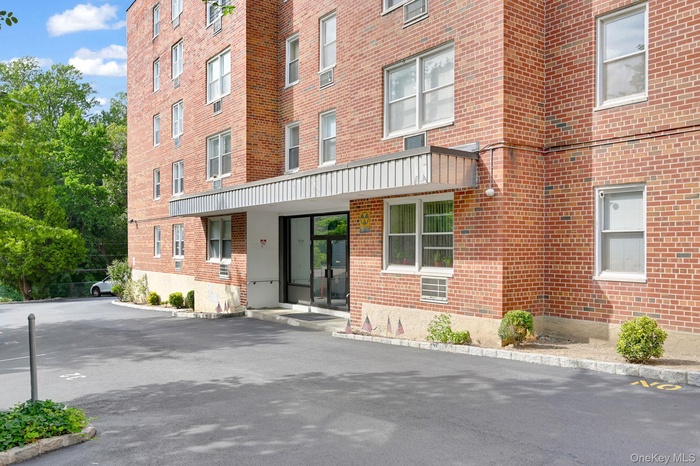 View of building exterior with uncovered parking