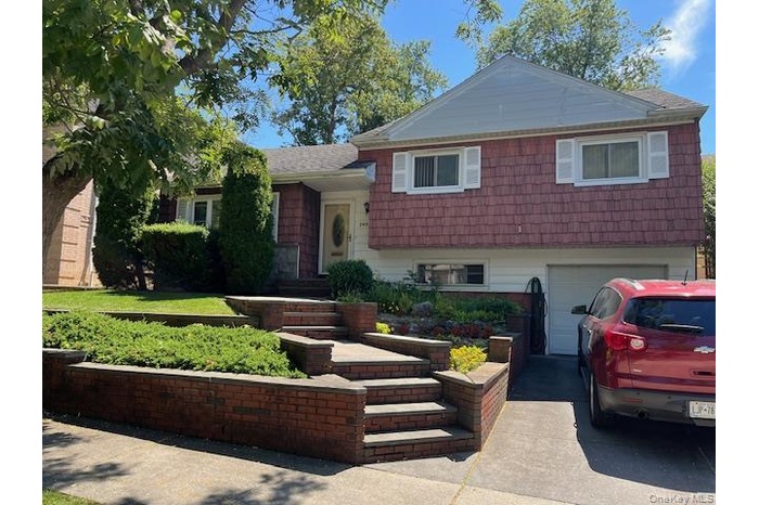 Tri-level home featuring a garage and driveway