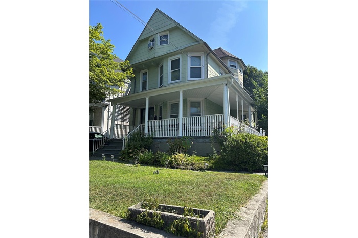 View of front of property featuring a front yard and covered porch