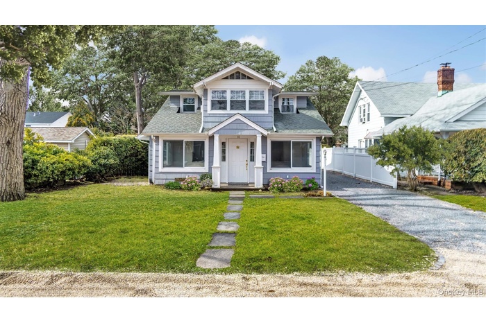 Bungalow-style home with a shingled roof and driveway