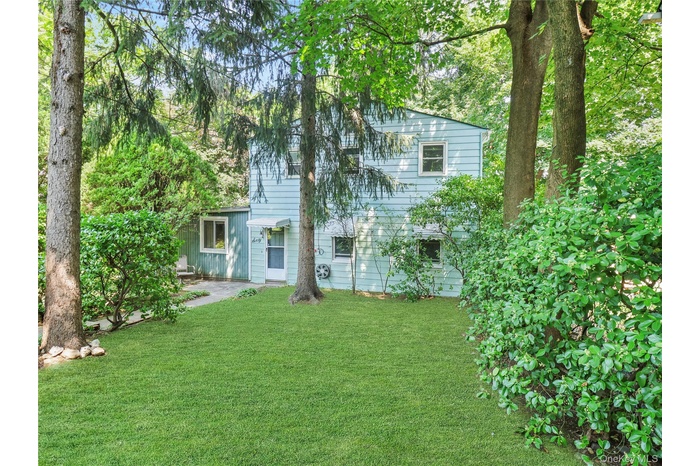 Back of house with a yard and a patio