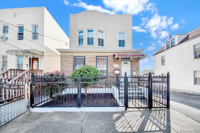 View of front facade with a gate, a fenced front yard, and stone siding
