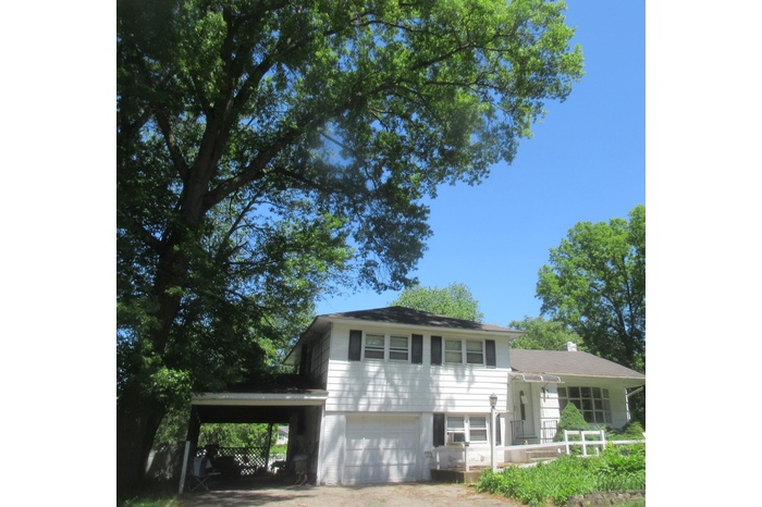 Split level home featuring an attached garage and an attached carport