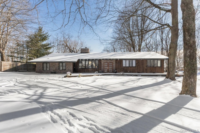 View of front of home with a chimney and brick siding