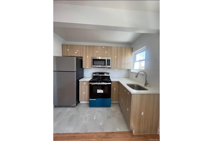 Kitchen featuring appliances with stainless steel finishes, tasteful backsplash, light stone countertops, modern cabinets, and brown cabinetry
