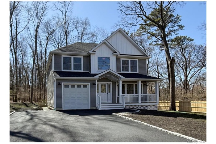 View of front of house with covered porch, asphalt driveway, and an attached garage