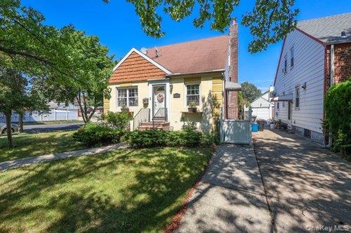 View of front of house with a front yard and a chimney