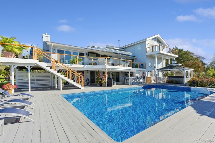 Outdoor pool with a patio, a wooden deck, stairs, and a gazebo