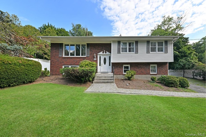 Raised ranch featuring brick siding