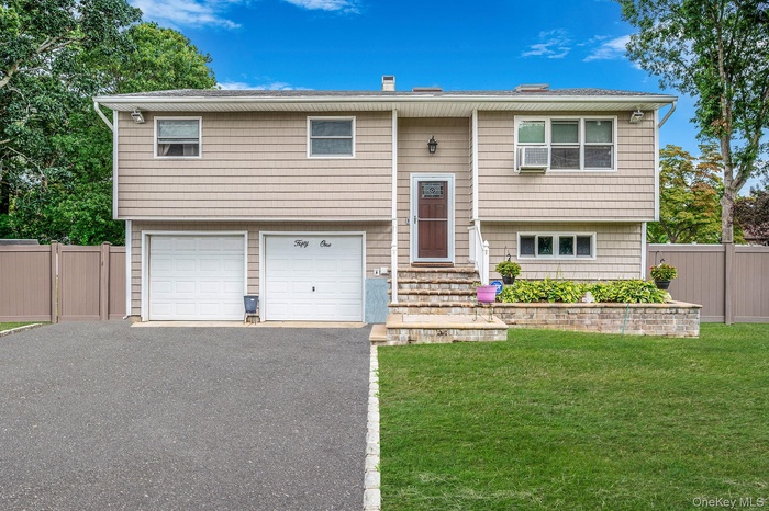 Split foyer home featuring an attached garage and asphalt driveway