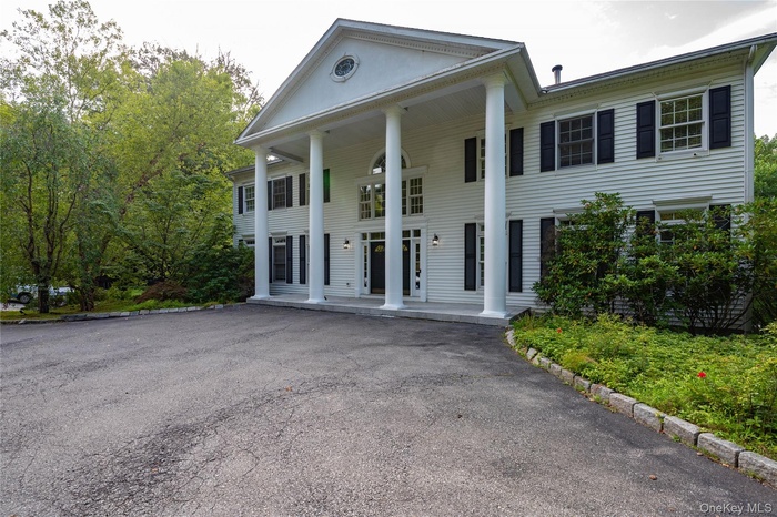 Neoclassical home featuring covered porch