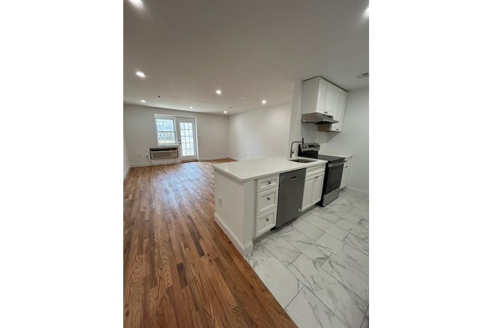 Kitchen with stove, extractor fan, dishwashing machine, open floor plan, and recessed lighting