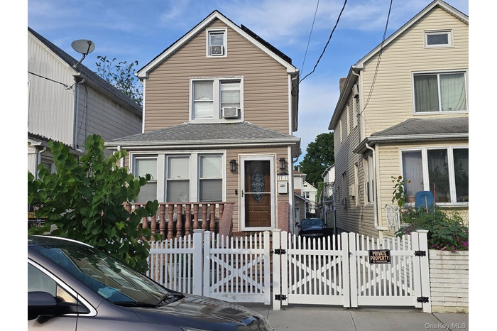 View of front facade with a gate, a fenced front yard, and roof with shingles