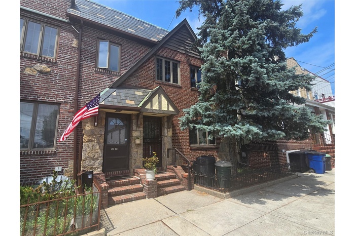 Tudor-style house featuring brick siding and a high end roof
