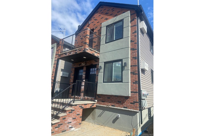 View of front of home with a balcony, brick siding, and crawl space