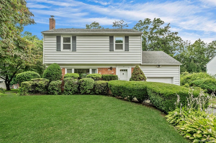 Welcome to 21 Pamela Lane! Colonial Style Home Featuring a Lovely Landscaped Yard and Brick Front