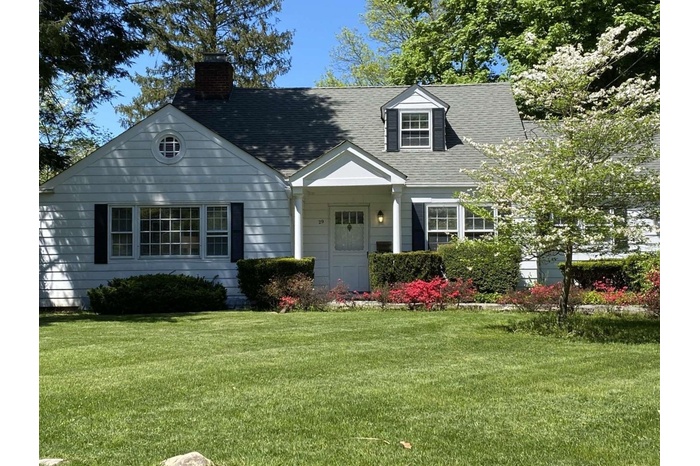 Cape cod-style house with a front lawn