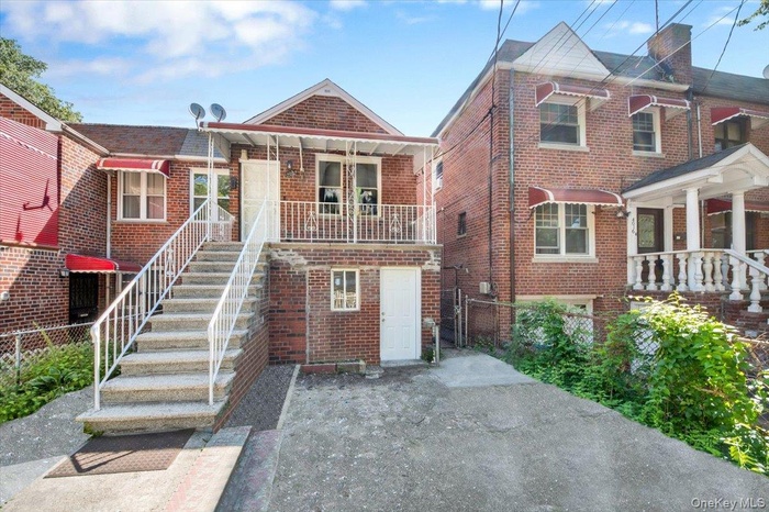 View of front facade featuring stairs and brick siding