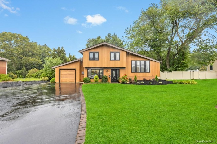 View of front of home with driveway and an attached garage