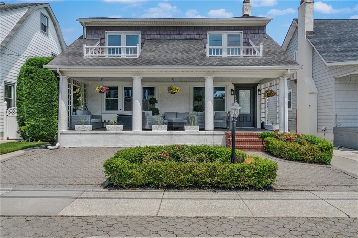 Bungalow featuring covered porch, a shingled roof, an outdoor living space, and a chimney