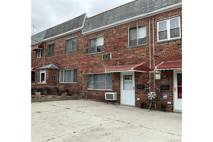 View of front of house with brick siding and mansard roof