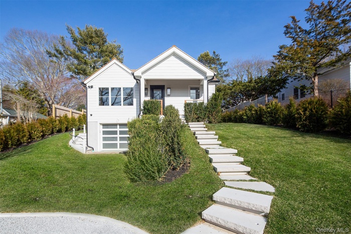 View of front of home featuring stairs and a front yard