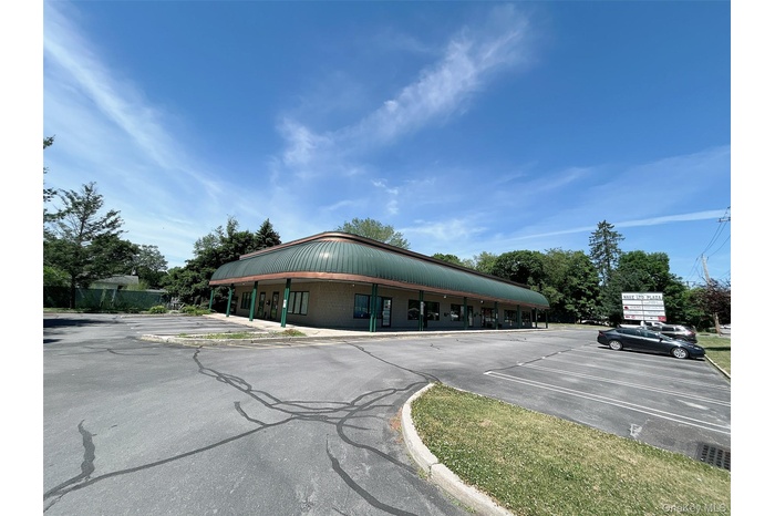 View of building exterior featuring uncovered parking