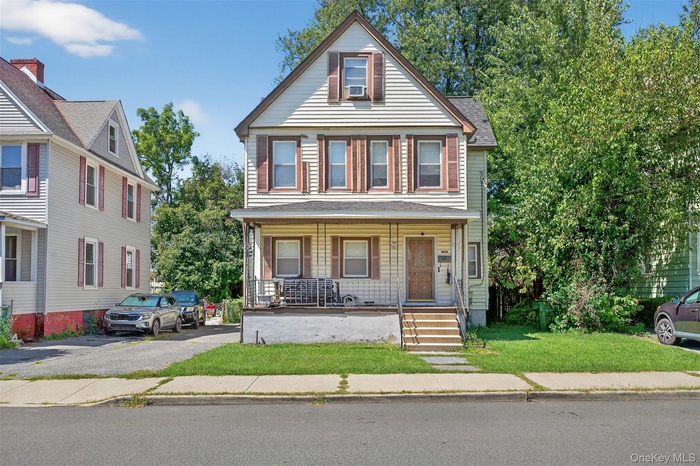 View of front of property with a porch and a front lawn