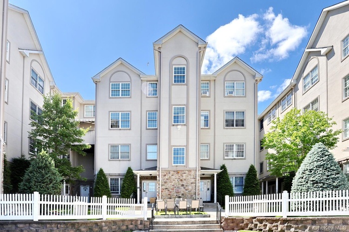 View of apartment building / complex featuring a fenced front yard