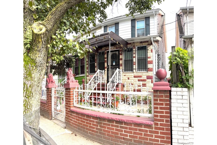 View of front of property with a fenced front yard and a gate
