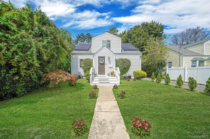 View of front facade with solar panels and a front yard