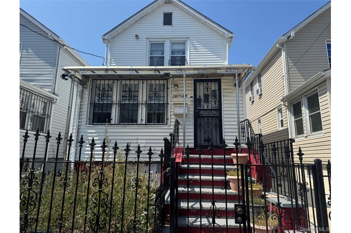 View of front facade featuring a fenced front yard and a gate