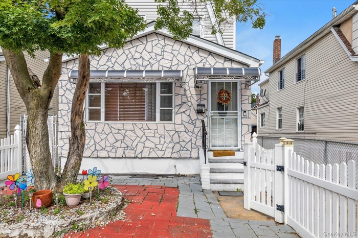 View of front facade with a gate and stone siding