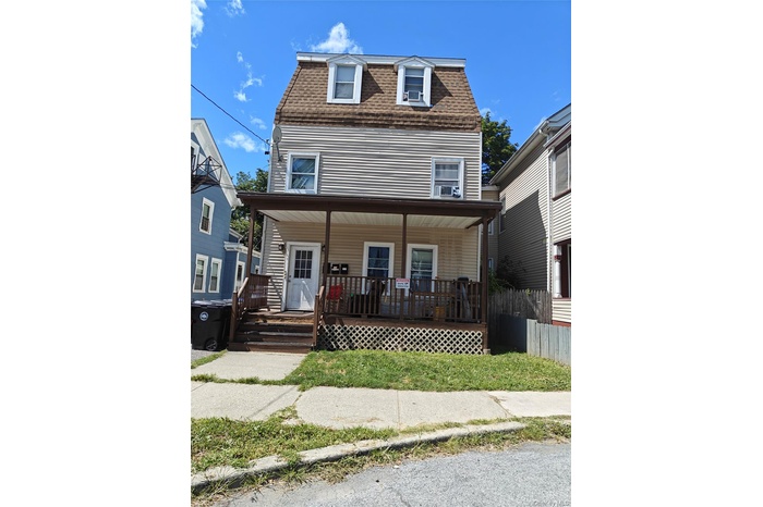 View of front of house with a shingled roof, covered porch, and mansard roof