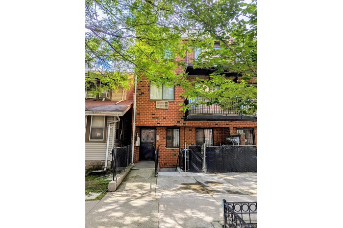 View of front of property featuring brick siding and a gate