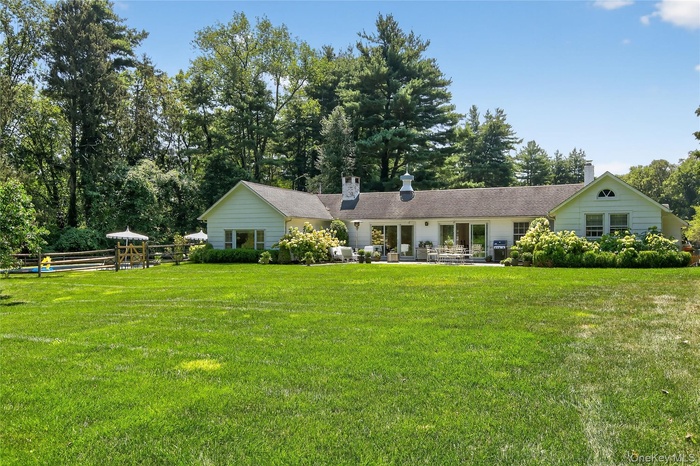 Single story home with a chimney and a patio