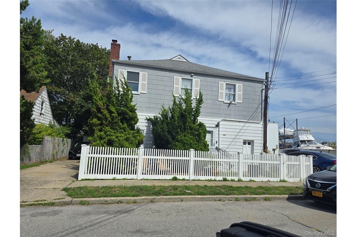 View of front facade with a fenced front yard and a chimney