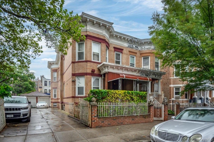 Italianate house with brick siding, an outdoor structure, and a garage