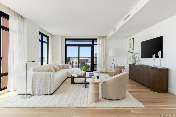 Living area featuring light wood-style flooring and expansive windows