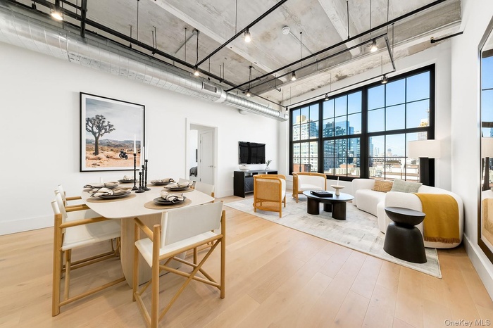 Dining room featuring light wood-style floors, a high ceiling, and track lighting