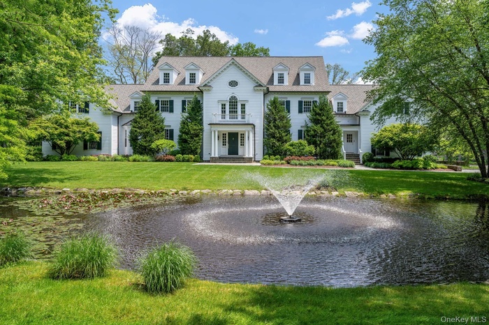 View of front of home featuring a water view and a front lawn
