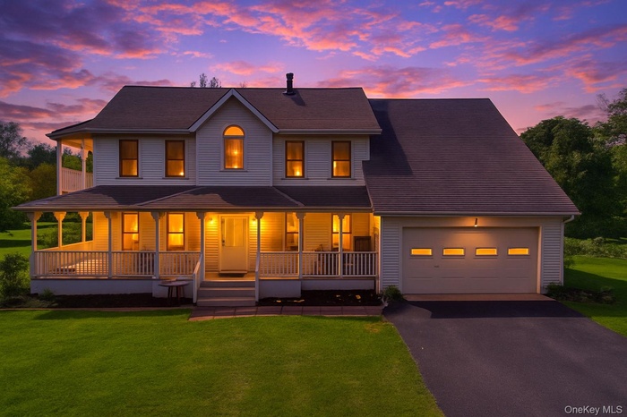 View of front of home featuring covered porch, driveway, and a front lawn