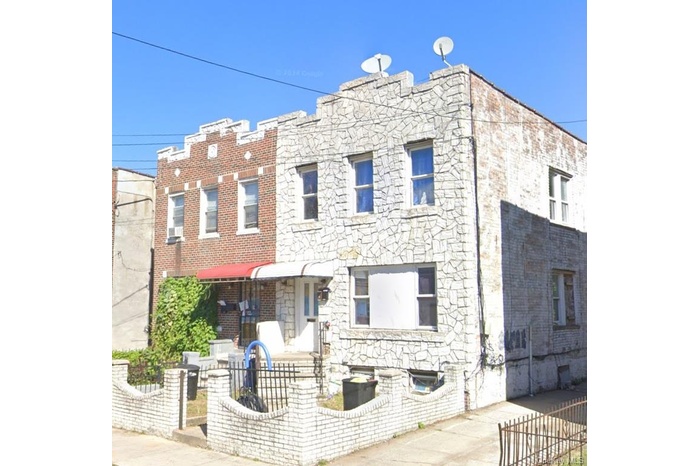 View of front facade featuring a fenced front yard and stone siding