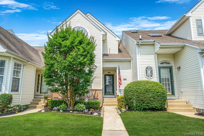 View of front of property featuring entry steps, a front lawn, and roof with shingles
