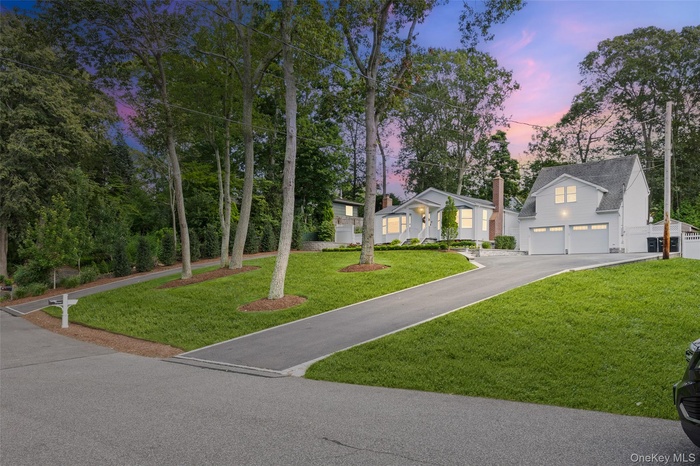 View of front of home featuring driveway and a front yard