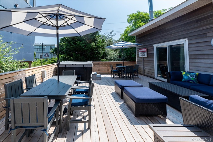 Deck with outdoor dining area, a hot tub, and an outdoor living space