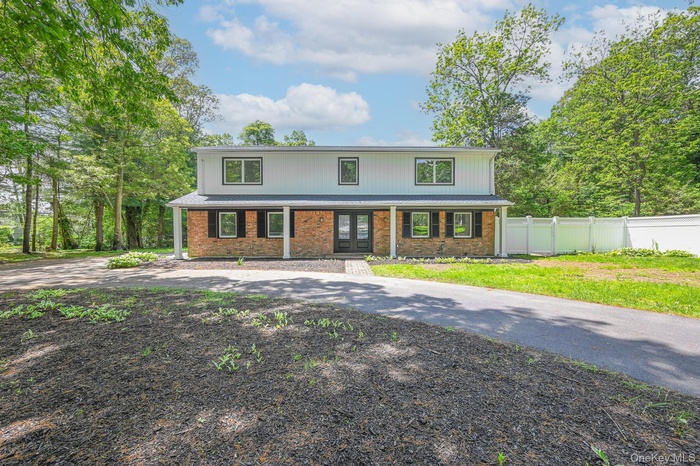 View of front of property featuring a porch and brick siding